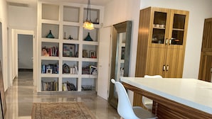 A modern kitchen with a wooden countertop, two white bar stools, and a built-in wooden cabinet. - Pardes Villa (Pardes Hanna-Karkur)