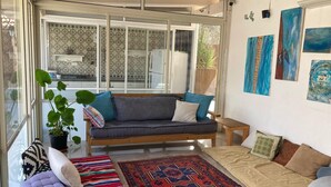 A cozy living room with a sofa, a bench, and a patterned rug. - Pardes Villa (Pardes Hanna-Karkur)