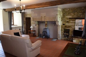 A cozy living room with a stone fireplace, a sofa, and a television.