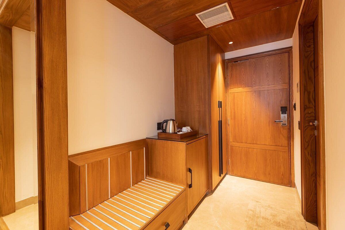 A compact room with a wooden bench, a small cabinet, and a door.