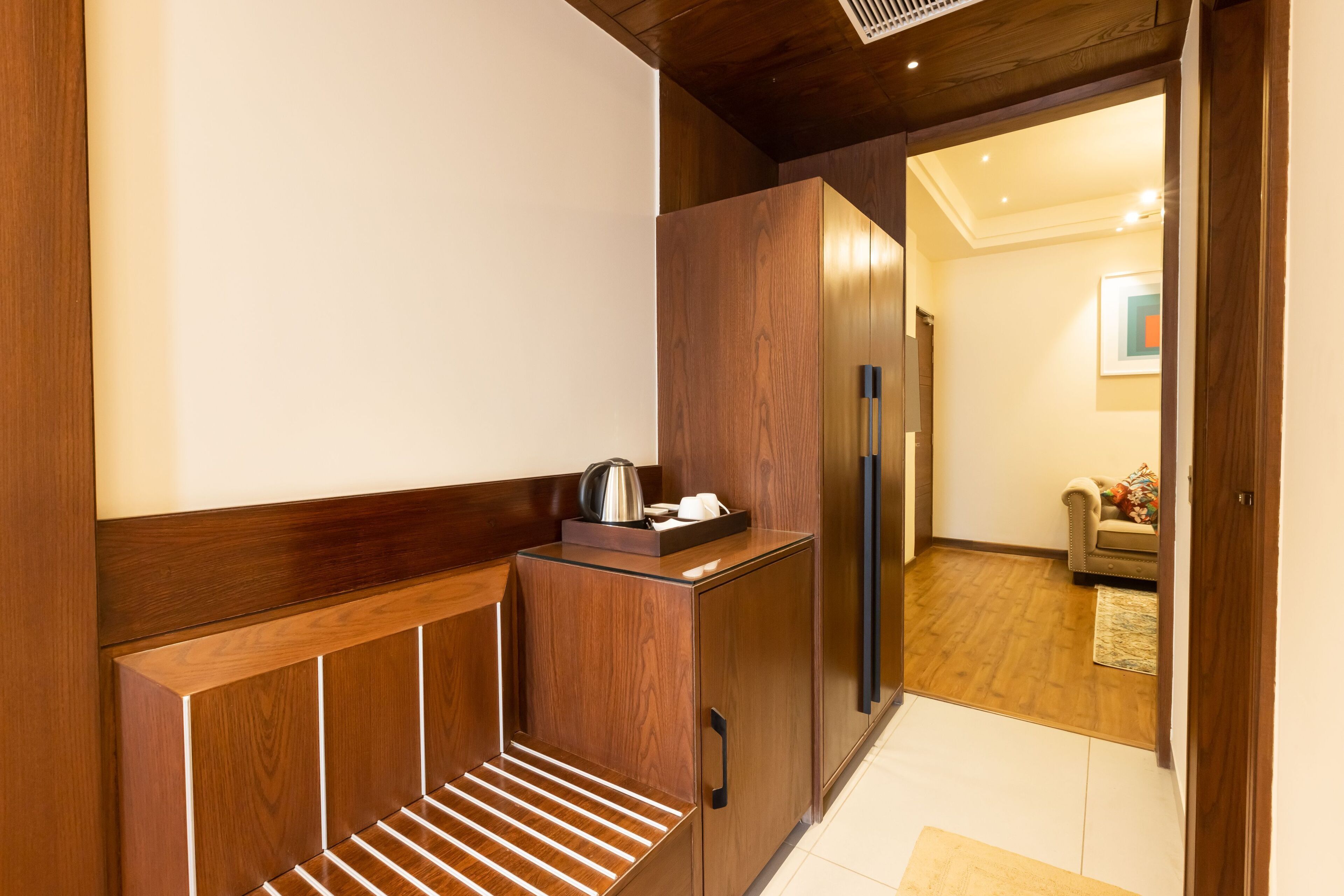 A modern kitchen with wooden cabinetry, a built-in bench, and a refrigerator.
