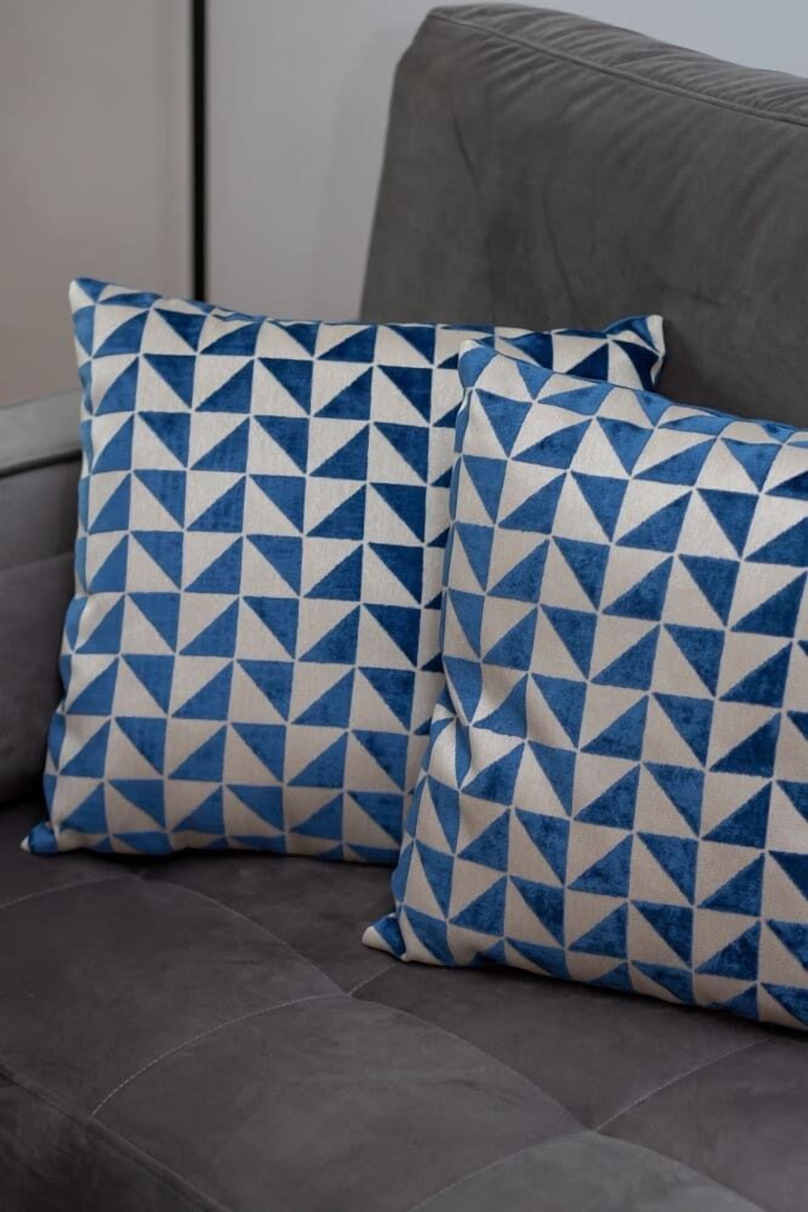 Ein graues Sofa mit zwei blau-weißen Kissen.