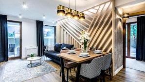 Un comedor moderno con una mesa de madera, sillas estampadas en blanco y negro, y una lámpara colgante.
