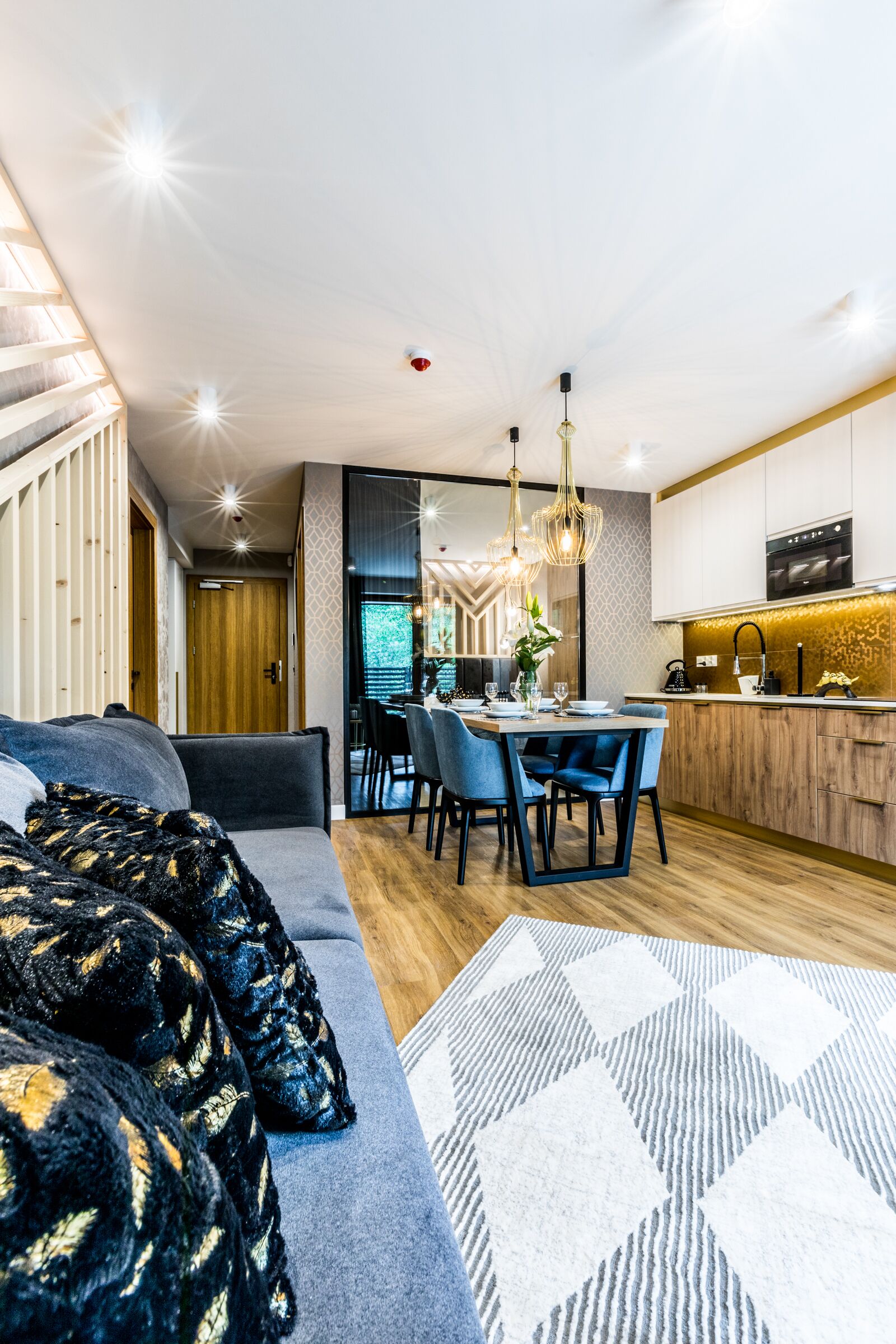 Um interior moderno com área de refeições, cozinha e espaço para sentar.