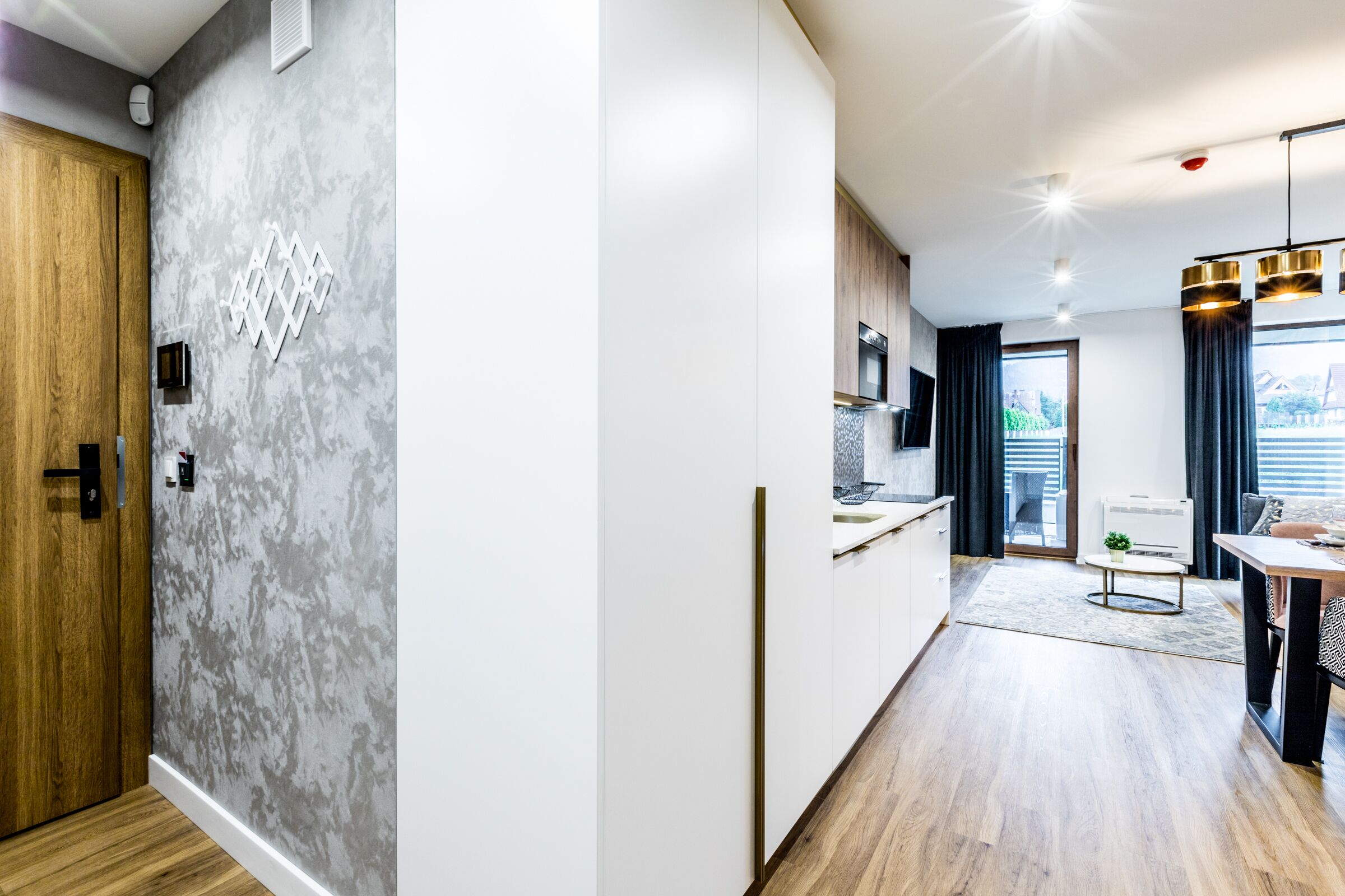Een moderne keuken met een ingebouwde oven en een eethoek met een tafel en stoelen.