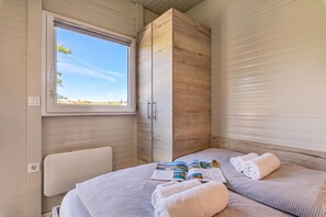 Una habitación con una cama, una ventana y un armario de madera.
