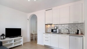 Una cucina moderna con mobili bianchi, un forno a microonde integrato e una lavastoviglie.