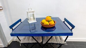 A table with a bowl of fruit and a white lantern.