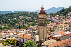 A town with a prominent clock tower, surrounded by residential buildings and greenery.