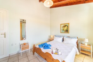A bedroom with a wooden bed, bedside tables, a mirror, and a painting on the wall.