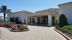 Ein Gebäude mit Ziegeldach, überdachter Eingang und gepflastertem Innenhof.