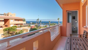 A balcony with a view of the sea, a bench, and a door leading to an interior space. - Holiday Home 'Vista Mar' with Sea Views, Shared Pool and Wi-Fi (Puertito de Güímar)