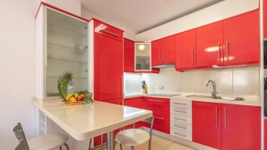 A kitchen with red cabinets, a white countertop, and a sink. - Holiday Home 'Vista Mar' with Sea Views, Shared Pool and Wi-Fi (Puertito de Güímar)