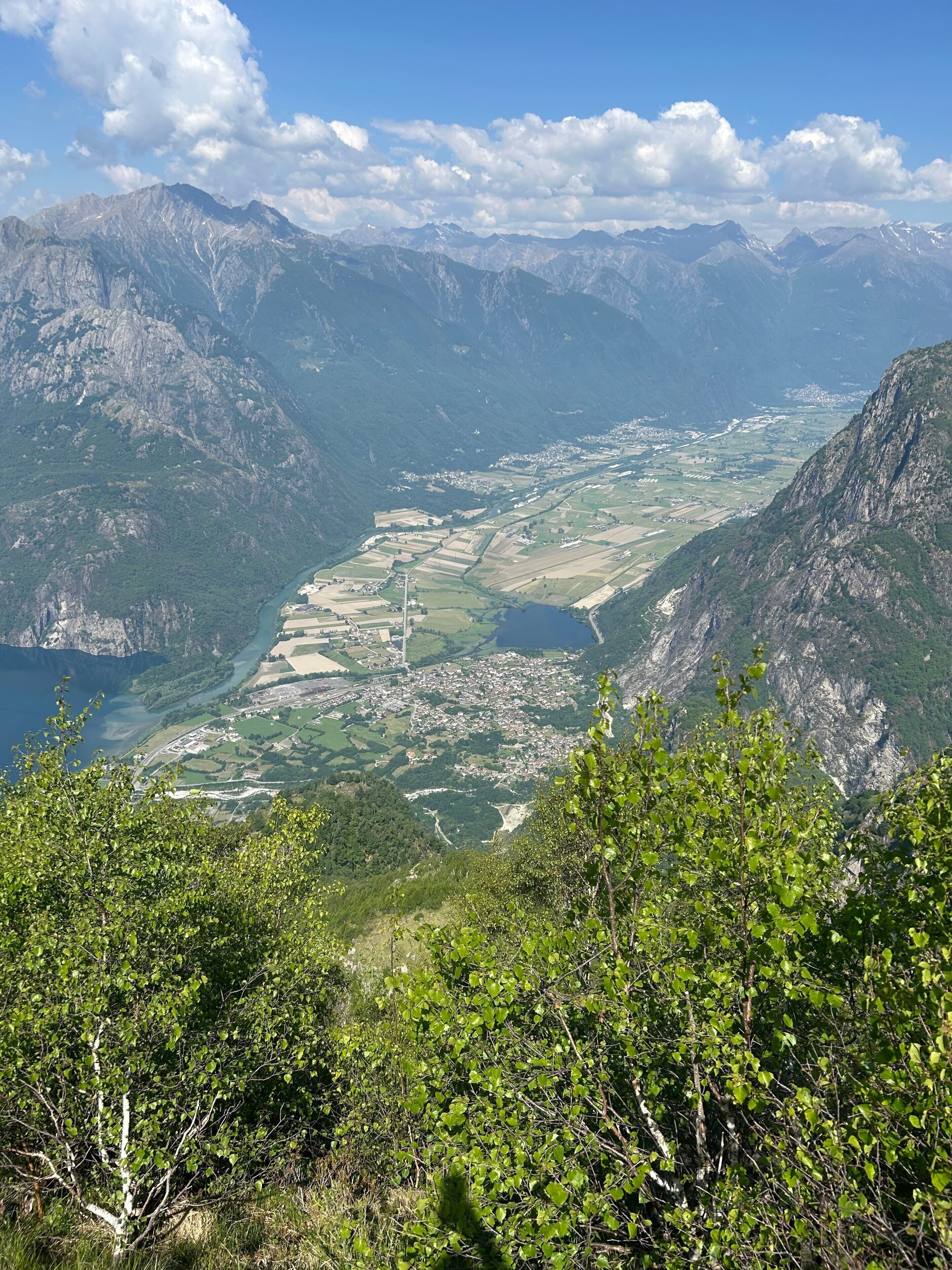 A mountainous landscape with a valley, a river, and a small town.