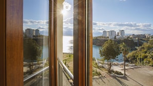 A view from a window overlooking a coastal area with buildings and a clear sky. - Qinn Hotels (Antalya)