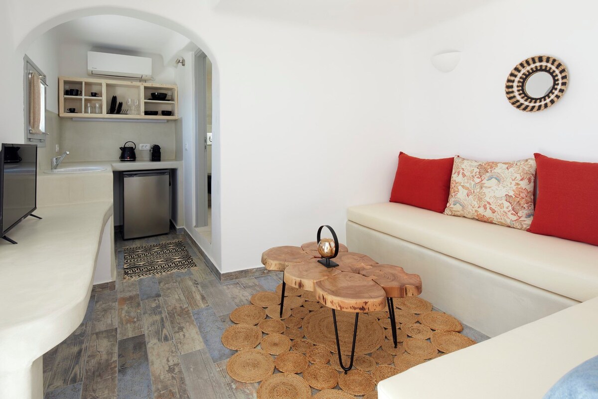 A modern living room with a sofa, a coffee table, and a kitchen in the background.
