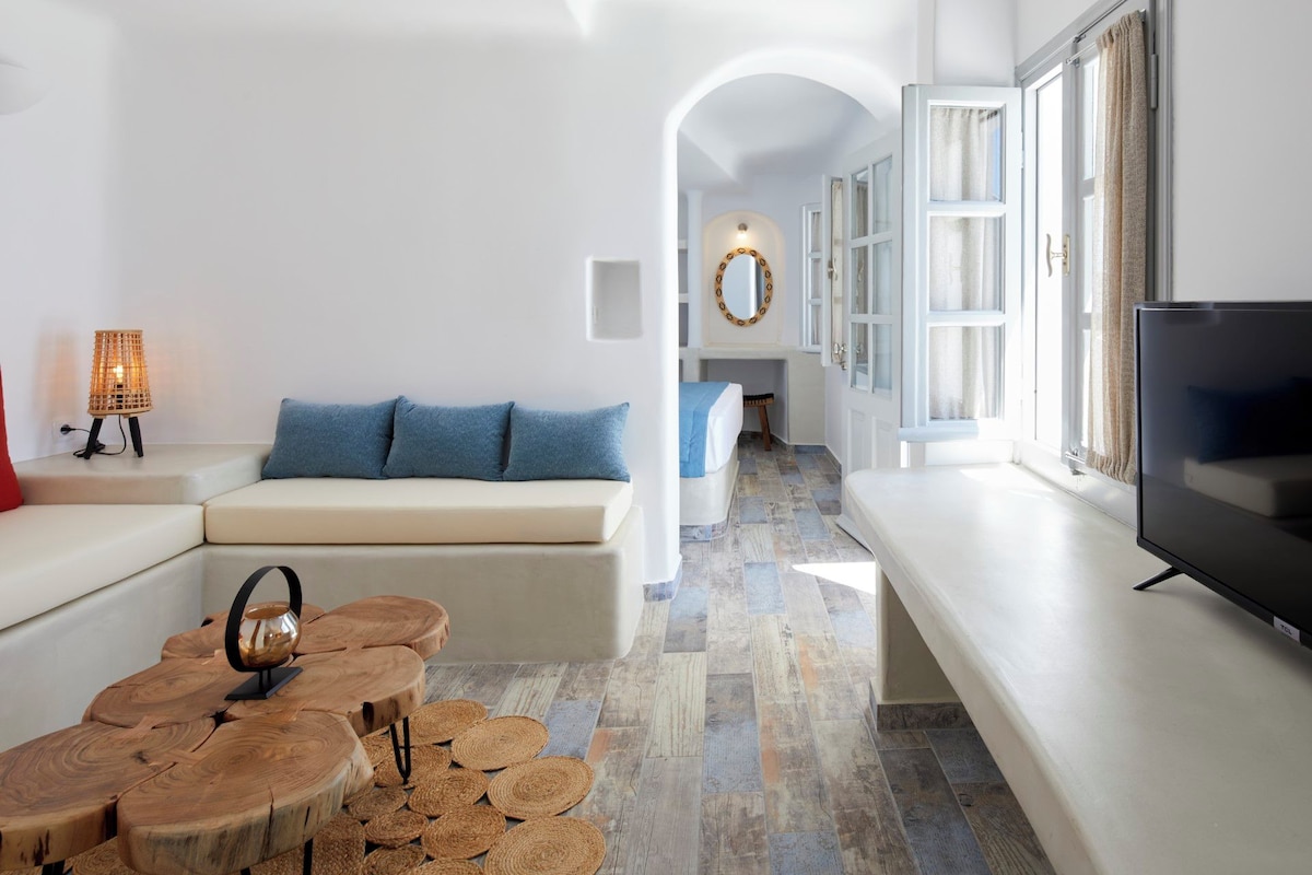 A modern living room with a sofa, a coffee table, a TV, and a unique wooden coffee table.