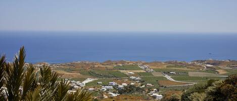 A coastal village with white buildings, a winding road, and a view of the sea.