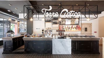 A bar area with a sign reading "Torre Cativa" and a variety of bottles and glasses on display.
