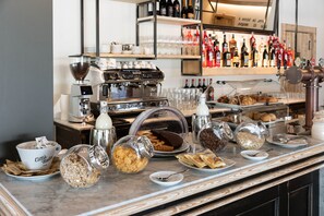 A breakfast bar with various food items, a coffee machine, and a selection of wine bottles. - Torre Antica Venice Airport Hotel (Mestre)