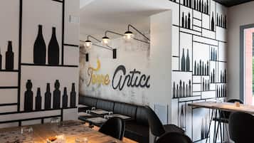 Ein Restaurantinneres mit einer zentralen Sitzgruppe, Schwarz-Weiß-Wandgestaltung und einem Menüständer.
