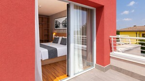 Un dormitorio con cama, armario y puerta corrediza de vidrio que da a un balcón.