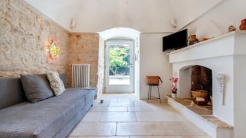 Family Villa, Multiple Bedrooms, 2 Bathrooms (Trullo Fedele Grande125) | Living area | 21-inch TV with cable channels, fireplace