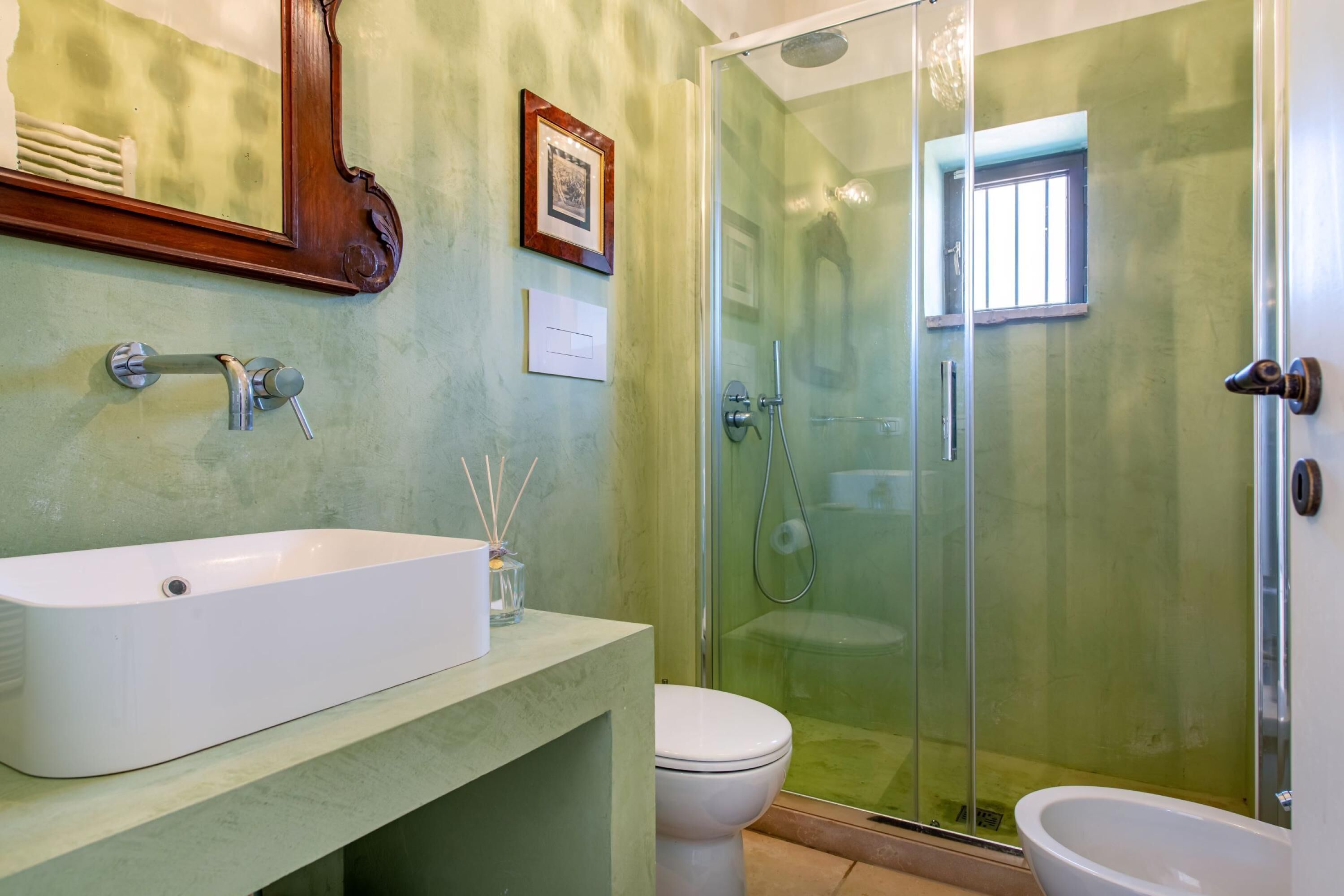 A bathroom with a freestanding bathtub, a toilet, and a glass-enclosed shower area.