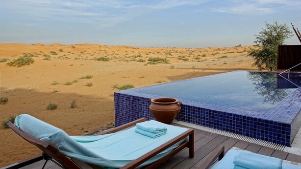A desert landscape with a swimming pool and lounge chairs. - Desert Drop (Jaisalmer)