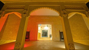An ornate entrance with a brick wall and decorative arches. - Desert Drop (Jaisalmer)