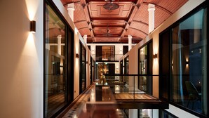 A modern hotel corridor with glass walls, wooden ceiling, and reflective flooring. - Heavens Hotel (Hoorn)