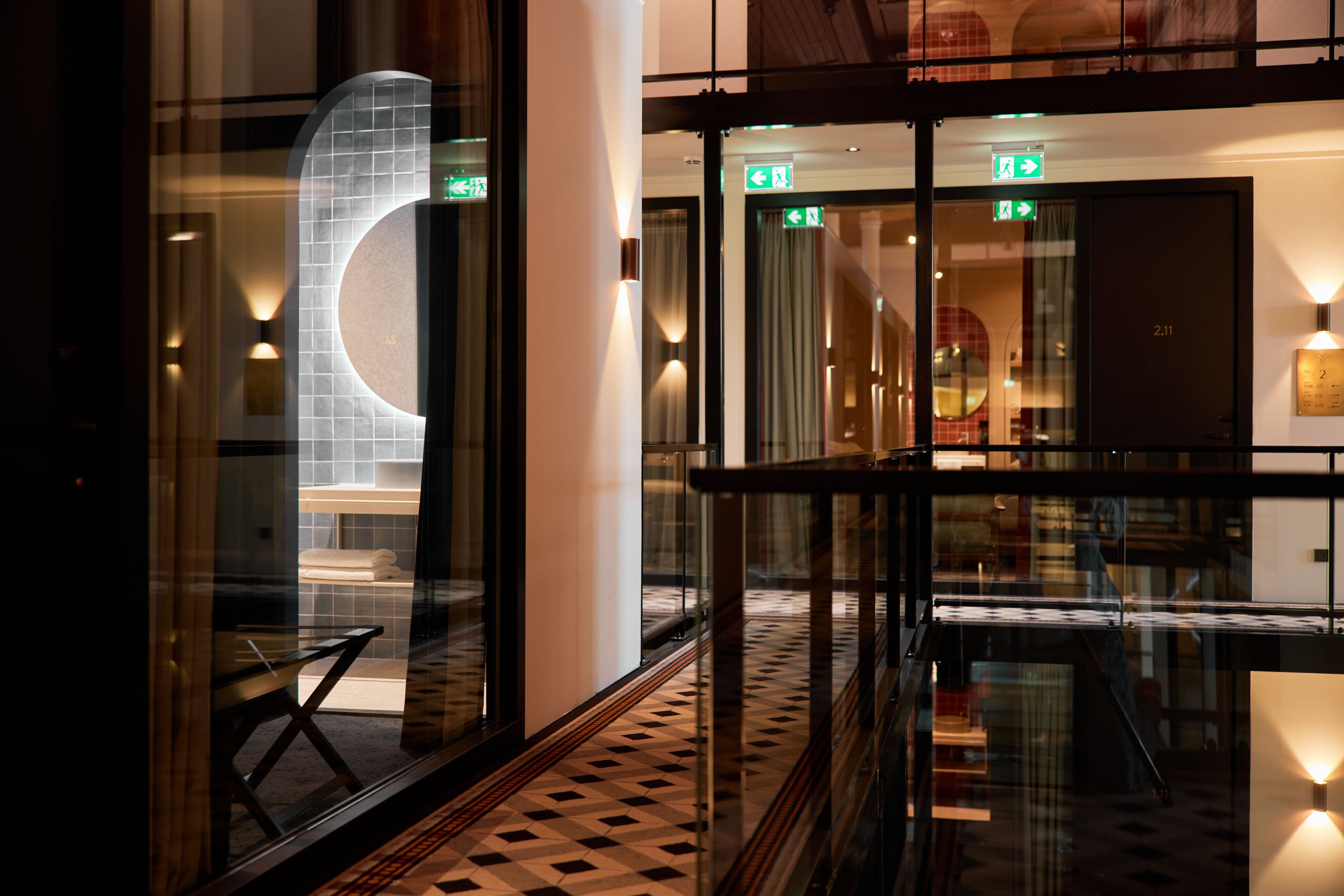 A hotel lobby with a check-in desk, a reception area, and a staircase.