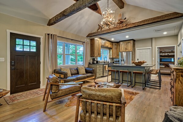 A spacious living area with a sofa, chairs, and a dining bar.