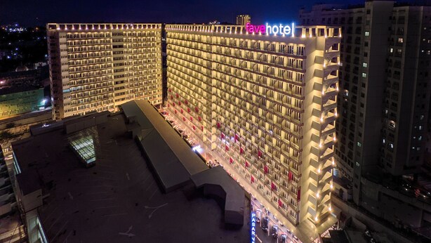 Un hôtel de grande hauteur doté d’un grand nombre de balcons et d’un espace aménagé sur le toit.