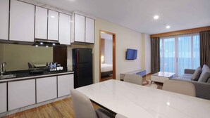 Une chambre d’hôtel moderne dotée d’une cuisine, d’un coin repas et d’un espace de vie.