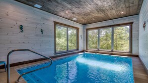 Une piscine intérieure avec des murs en bois et de grandes fenêtres.