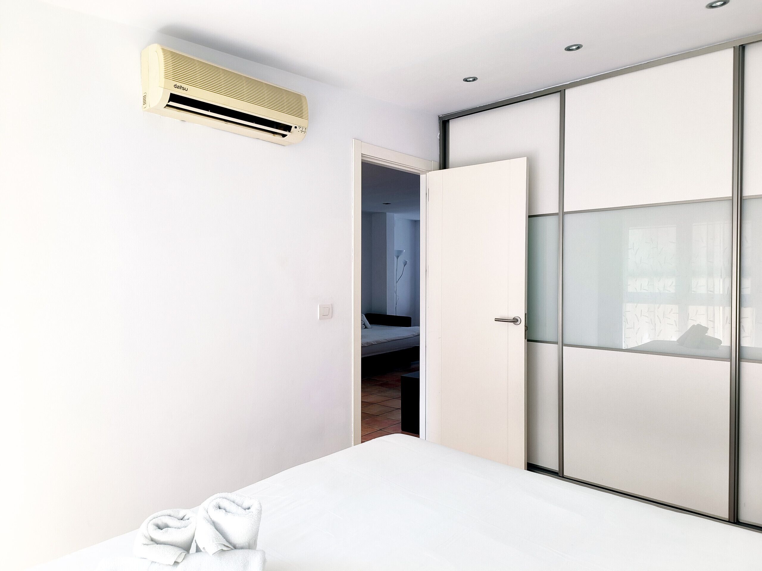 Une chambre à coucher comprenant un lit, une armoire et un appareil de climatisation.