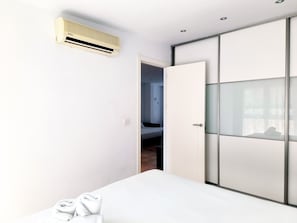 Une chambre moderne équipée d’un lit, d’une armoire et d’un appareil de climatisation.