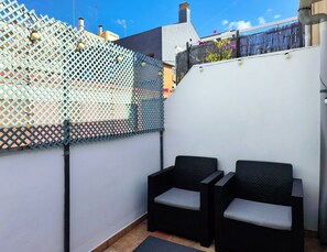 A small outdoor seating area with two black wicker chairs and a white wall. - Flats Friends Nave 1  bedroom with terrace (Valencia)