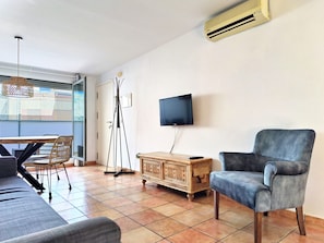 A living room with a sofa, a chair, a TV, and a floor lamp. - Flats Friends Nave 1  bedroom with terrace (Valencia)