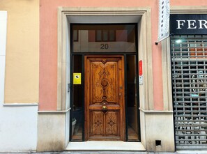 A wooden door with intricate carvings, a number '20' above it, and a sign indicating a parking area.