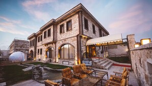 A historic stone building with outdoor seating and a small water feature. - Ahiyan Hotel (Nevsehir)