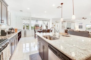 Enjoy cooking in this well-equipped kitchen with a large island, sink, and dishwasher.