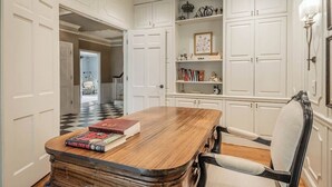 A room with a wooden table, a chair, and white cabinetry. - Spacious 5BR estate with Jacuzzi, pool, patio, and full kitchen. (Guntersville)