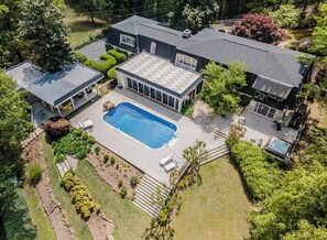 A residential property with a swimming pool, a covered patio, and a garden area. - Spacious 5BR estate with Jacuzzi, pool, patio, and full kitchen. (Guntersville)