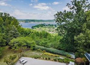 A lush green landscape with a view of a body of water and distant hills. - Spacious 5BR estate with Jacuzzi, pool, patio, and full kitchen. (Guntersville)
