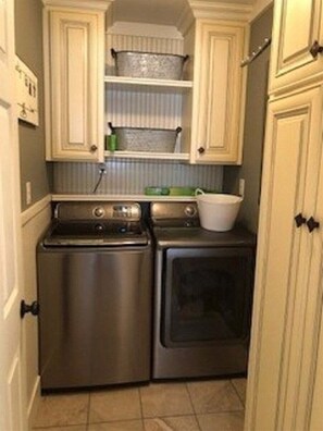 Una cocina compacta con estufa de acero inoxidable, horno y lavadora-secadora integrada.