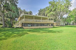A two-story building with a balcony, surrounded by trees. - Waterfront Welaka Escape w/ Private Docks! (Welaka)