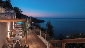Eine Seeterrasse mit Sitzgelegenheiten und Meerblick.