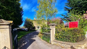 A gated entrance to a property with a sign indicating it is a guest house. - The Pines Guesthouse (Elgin)